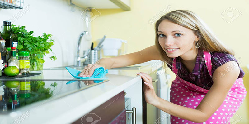 Mujer limpiando gabinete de cocina